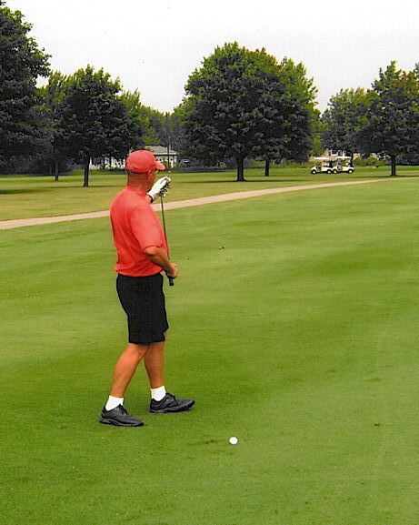 Bill Walter cleans off his iron to hit his approach into #10.